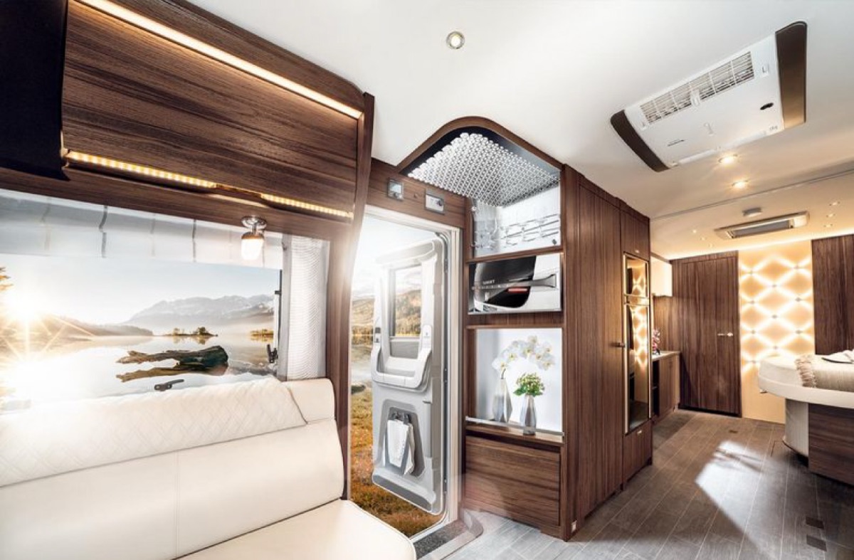 Caravan-Interieur mit Lounge-Bereich und Panoramablick auf die Berge